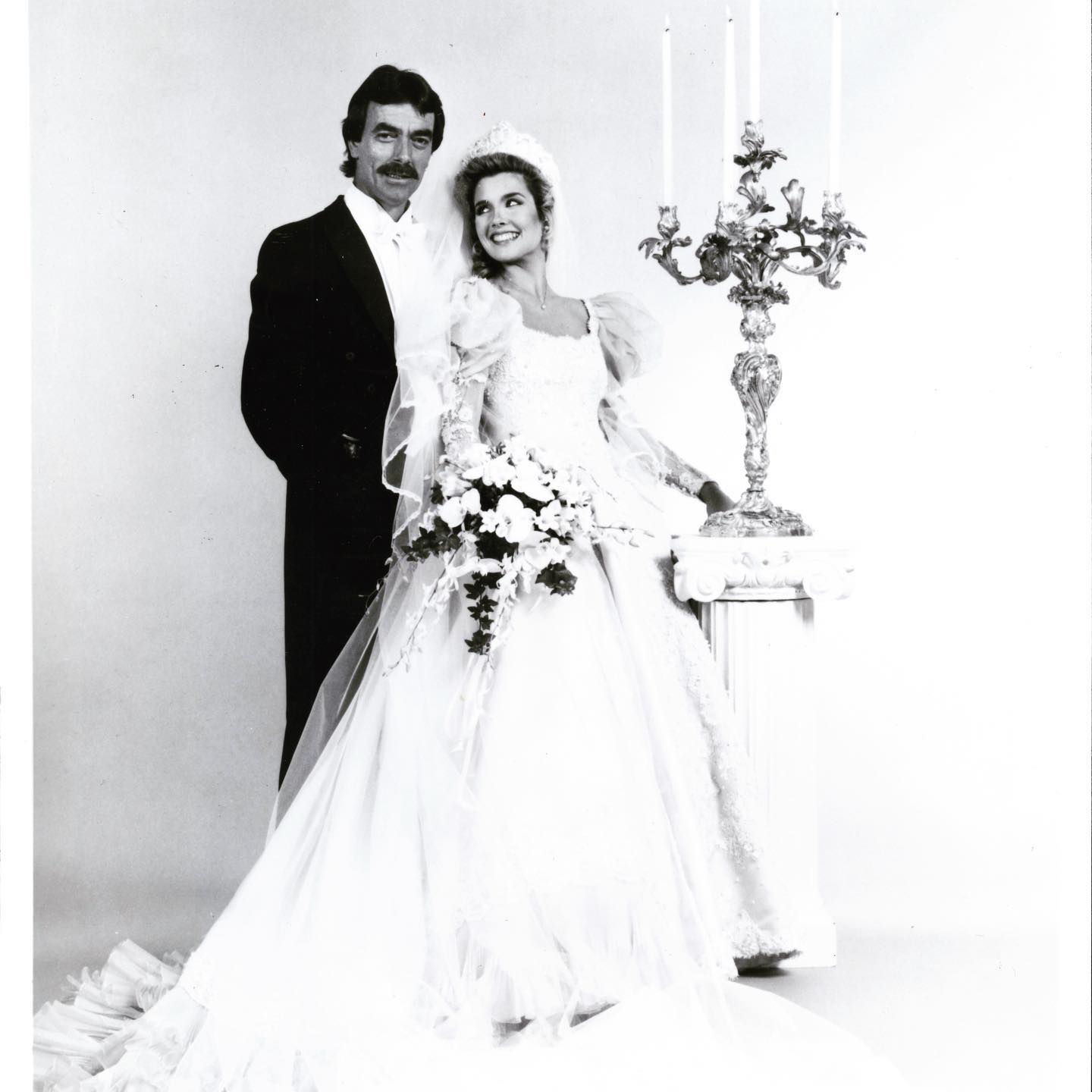 Black and white image of Melody Thomas Scott with Eric Braeden in wedding dress.
