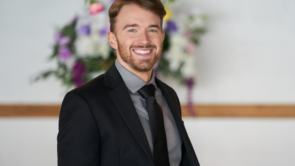 Chandler Massey dressed in a black suit. 