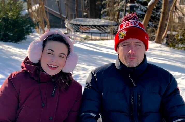 john reardon with wife meghan orr, john is wearing a red beanie, while meghan is wearing pink earmuffs